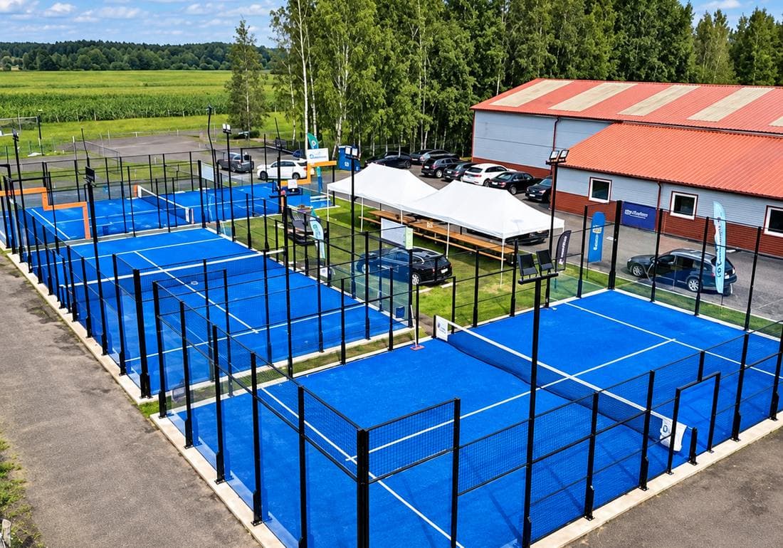 Trys mėlyni lauko padelio kortai Tennis1 aikštyne, vaizdas iš viršaus